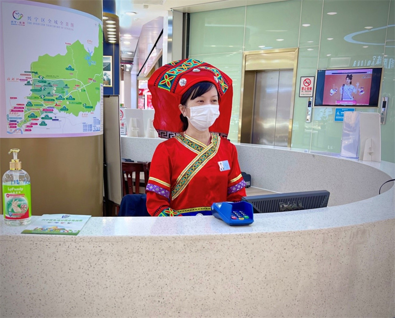 /QJ_981646124215.jpg 百貨朝陽店收銀員身穿壯族民族服裝接待顧客.jpg